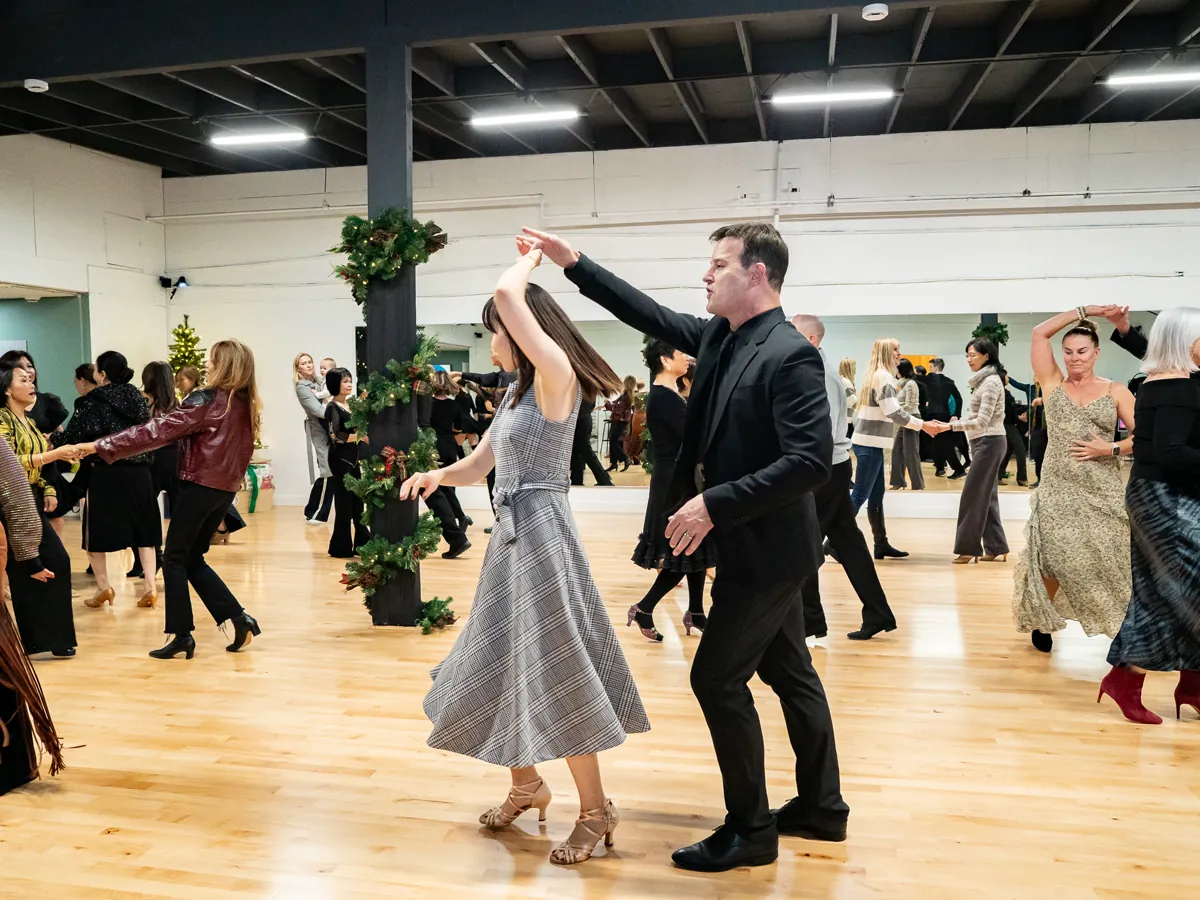Couples practice partner dancing together during an Alhambra studio social.