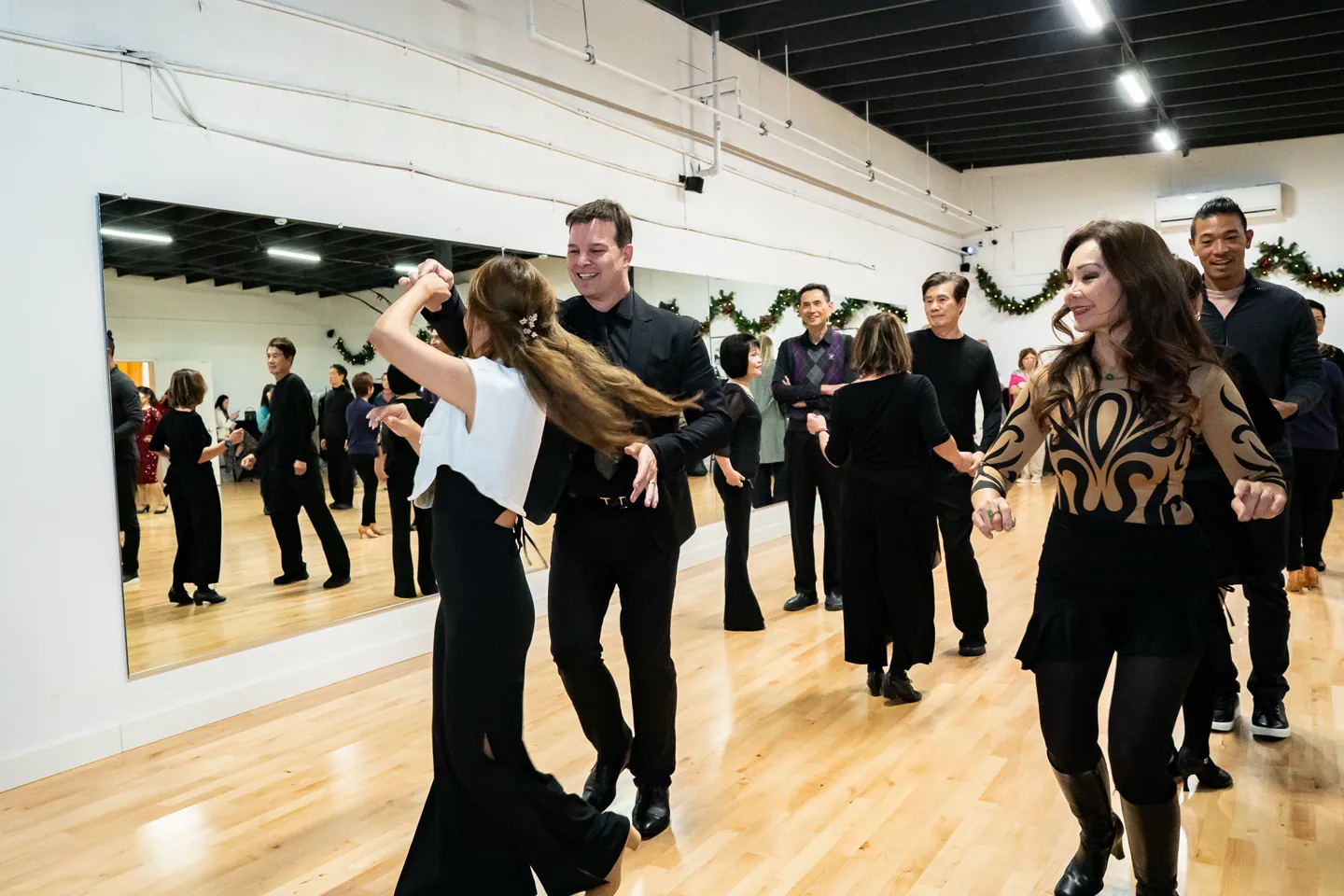 Adults practice ballroom dancing during a group lesson at Fred Astaire Dance Studios Alhambra.