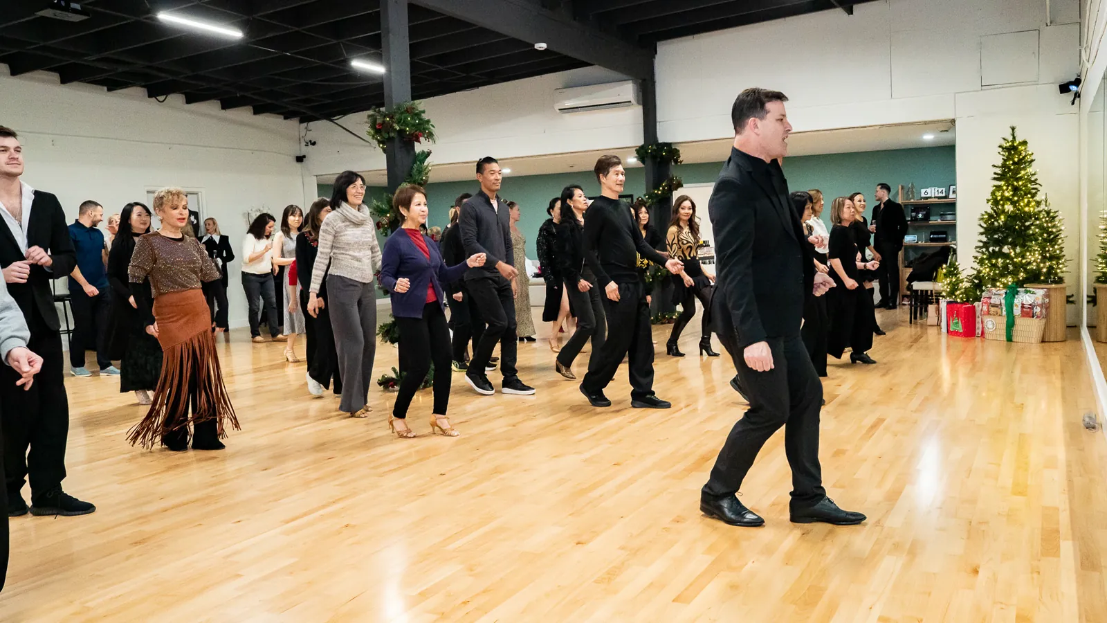 Adults follow an instructor during a group dance class at Fred Astaire Dance Studios Alhambra.